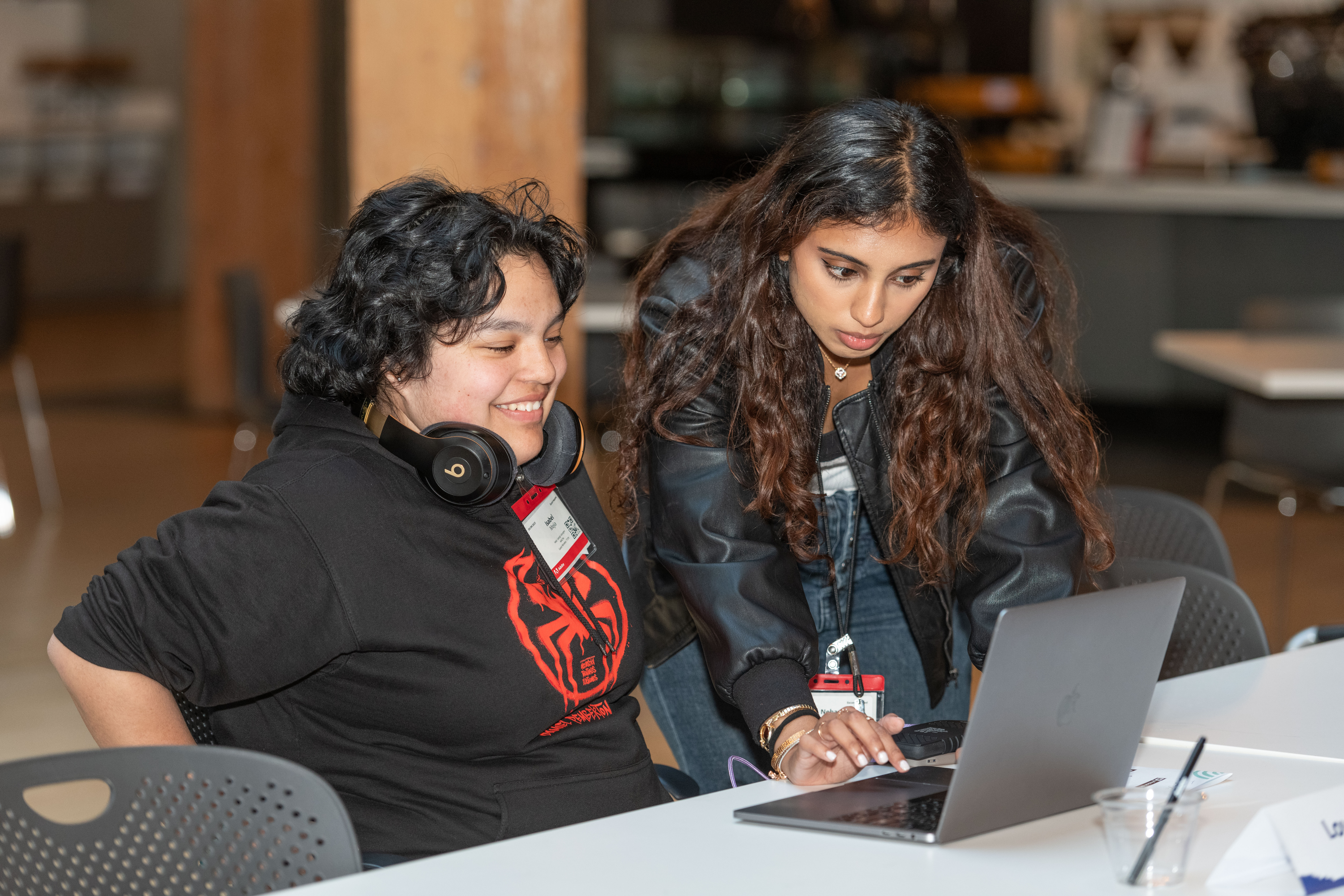 Two Mission Bit students collaborating on a laptop during Demo Day, where students present coding and computer science projects.