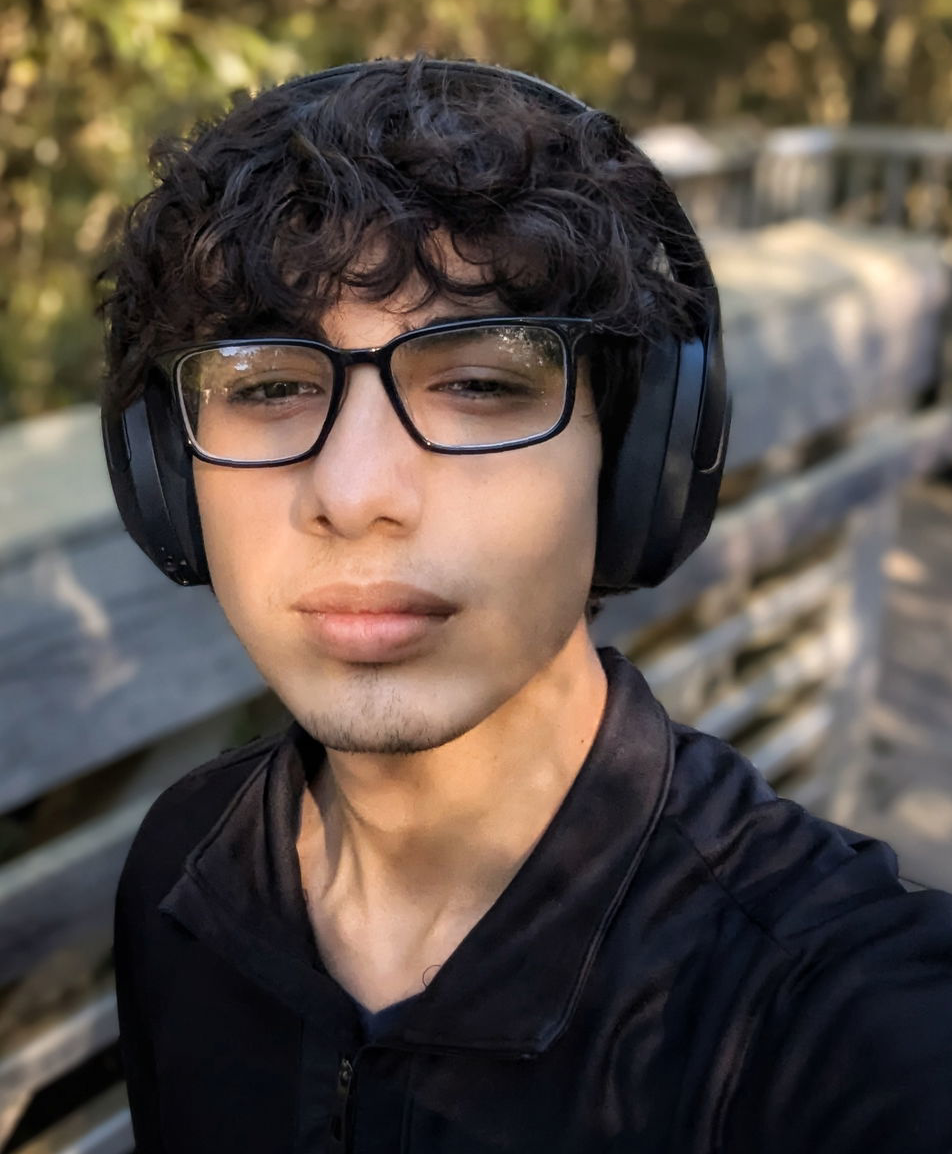 Mission Bit student wearing glasses and headphones outdoors, representing participants in the organization’s coding and computer science education programs.