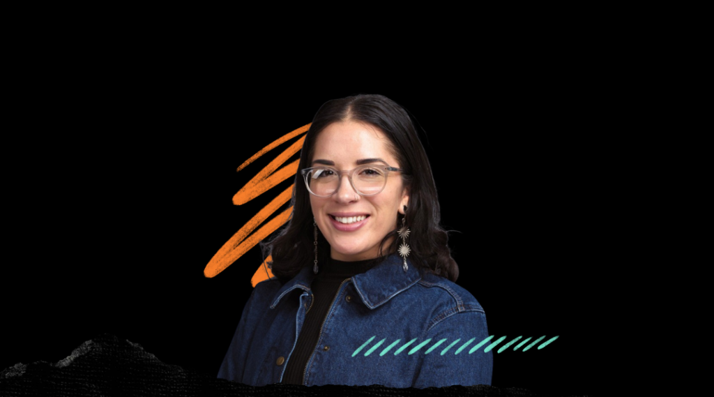 Portrait of Mission Bit CEO wearing glasses and a blue denim jacket, smiling.